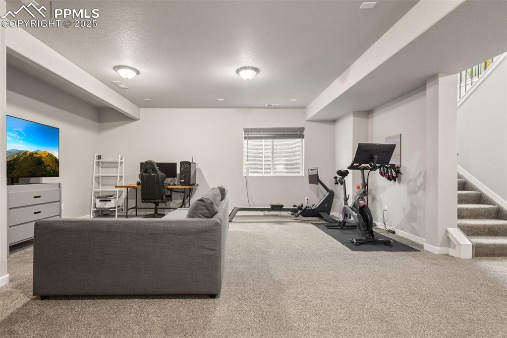 Exercise room featuring carpet and a textured ceiling