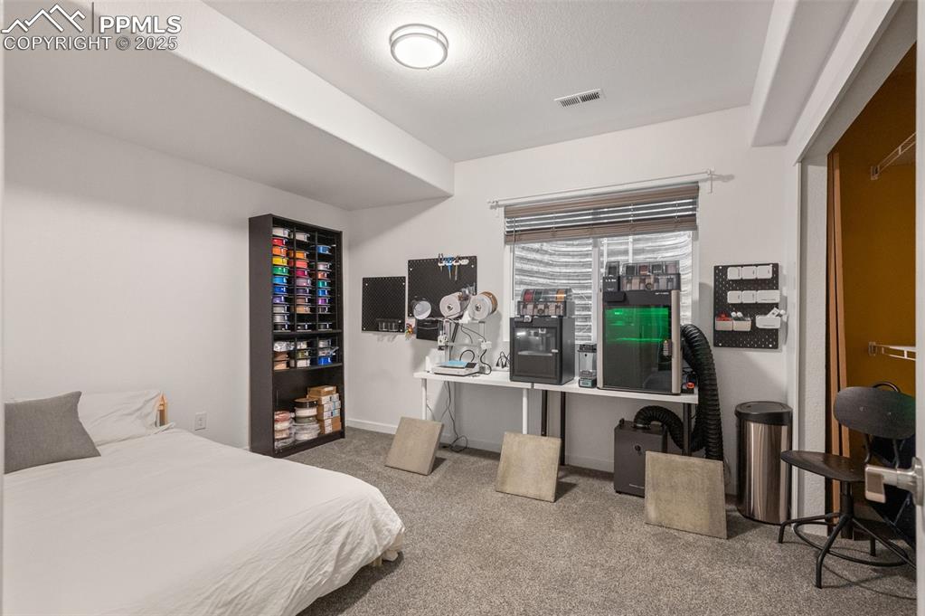Bedroom with light colored carpet and a textured ceiling