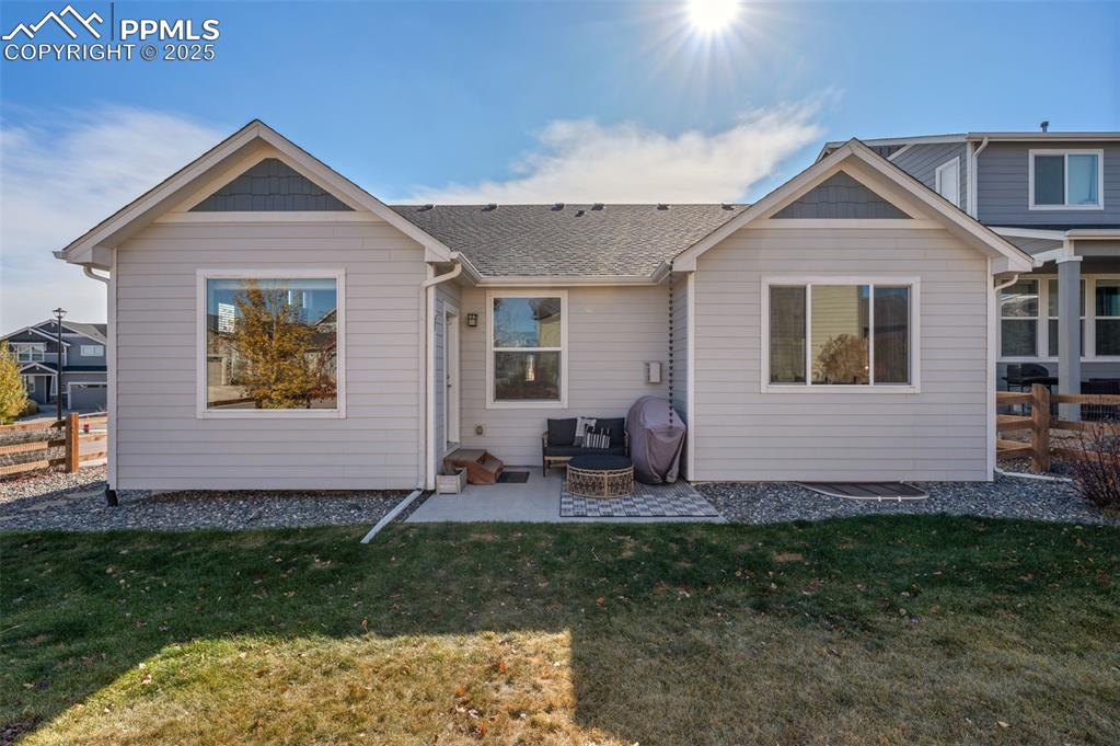 Rear view of house featuring a patio area and roof with shingles