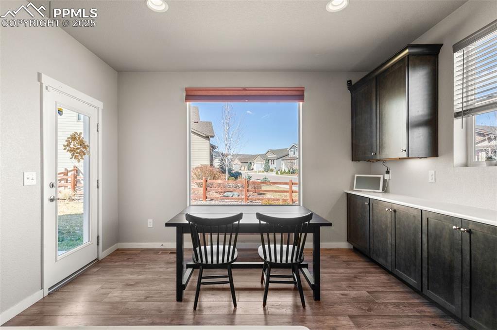Dining room with dark wood-style floors and recessed lighting