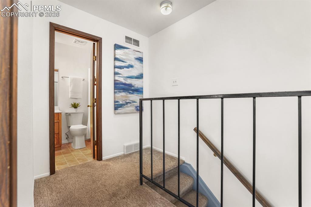 Upper level landing with view into the upper level Full Bathroom.