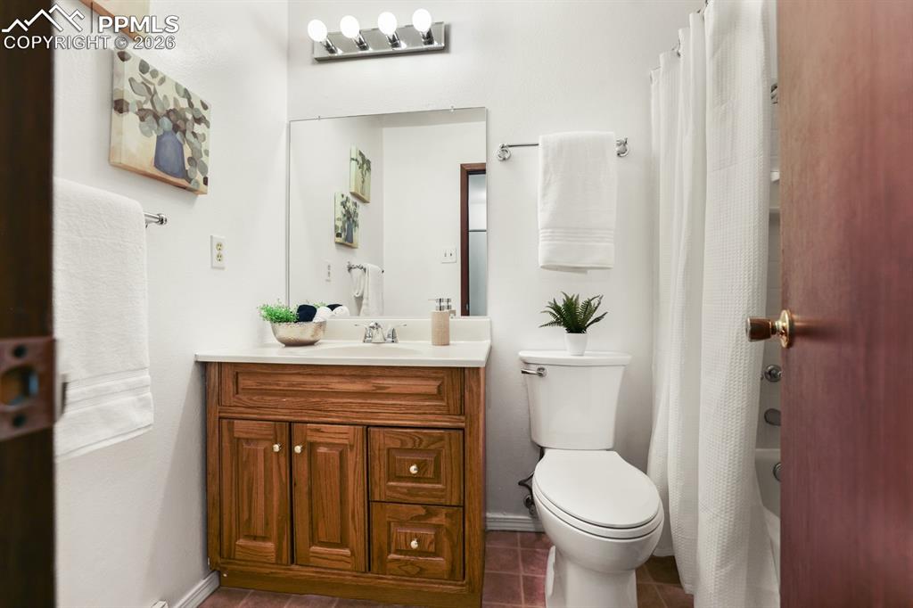 Upper Level Full Bathroom with vanity, mirror, toilet, and tub/shower.
