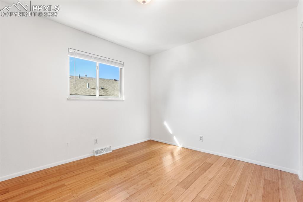 Upper Level Bedroom #2 with wood laminate floor and view window.