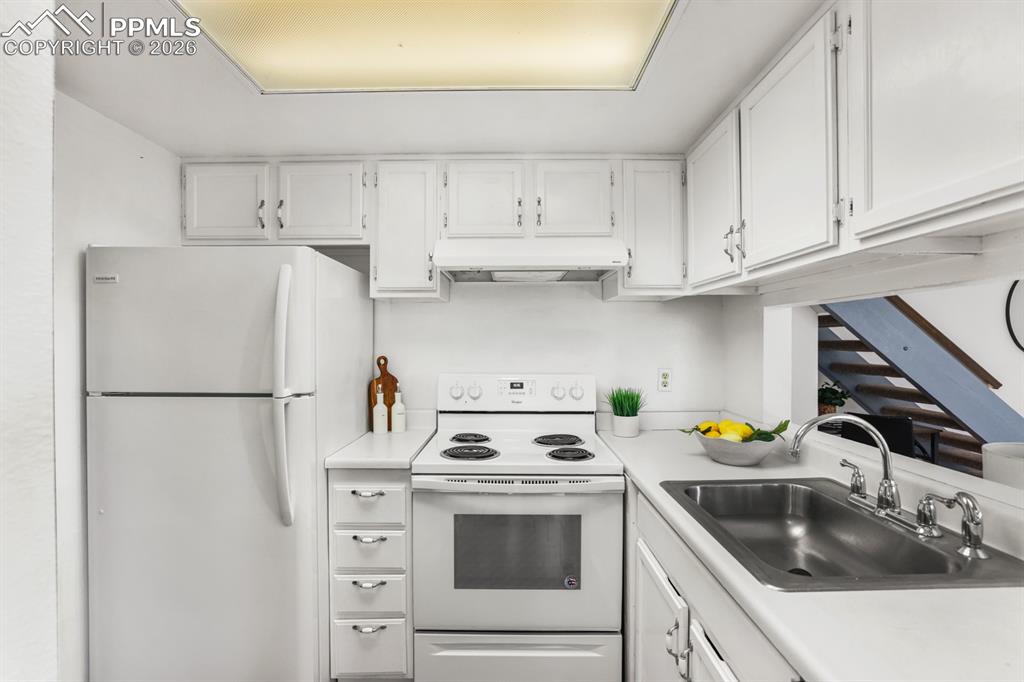  Bright & functional, the Kitchen boasts white cabinetry, abundant counterspace for storage & food preparation, a pantry, & direct garage access.