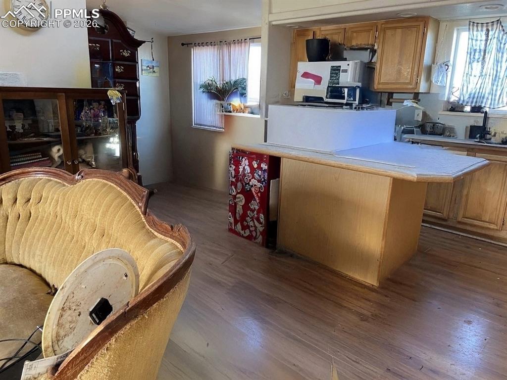 Kitchen with light countertops, dark wood-style flooring, wood finish cabinets, and a peninsula