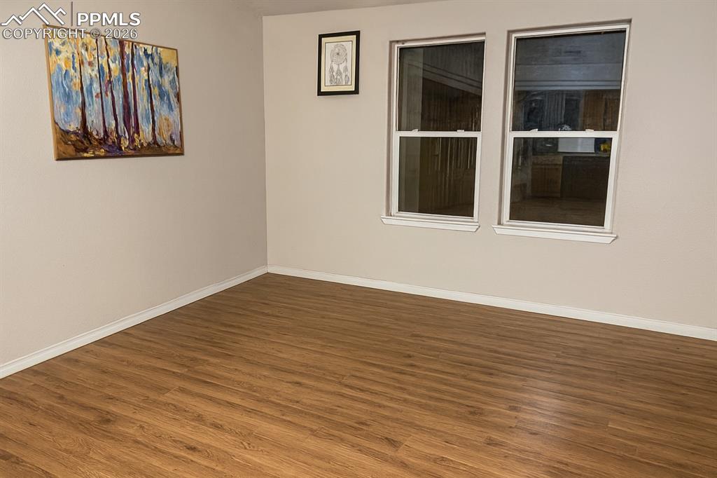 Unfurnished room with dark wood-style flooring