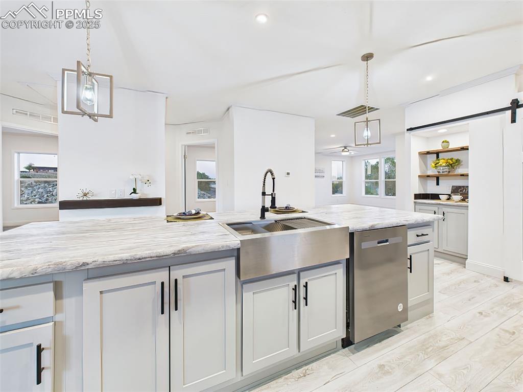 Functional island with farmhouse sink, high-arc black faucet, and integrated dishwasher—beautiful and efficient.