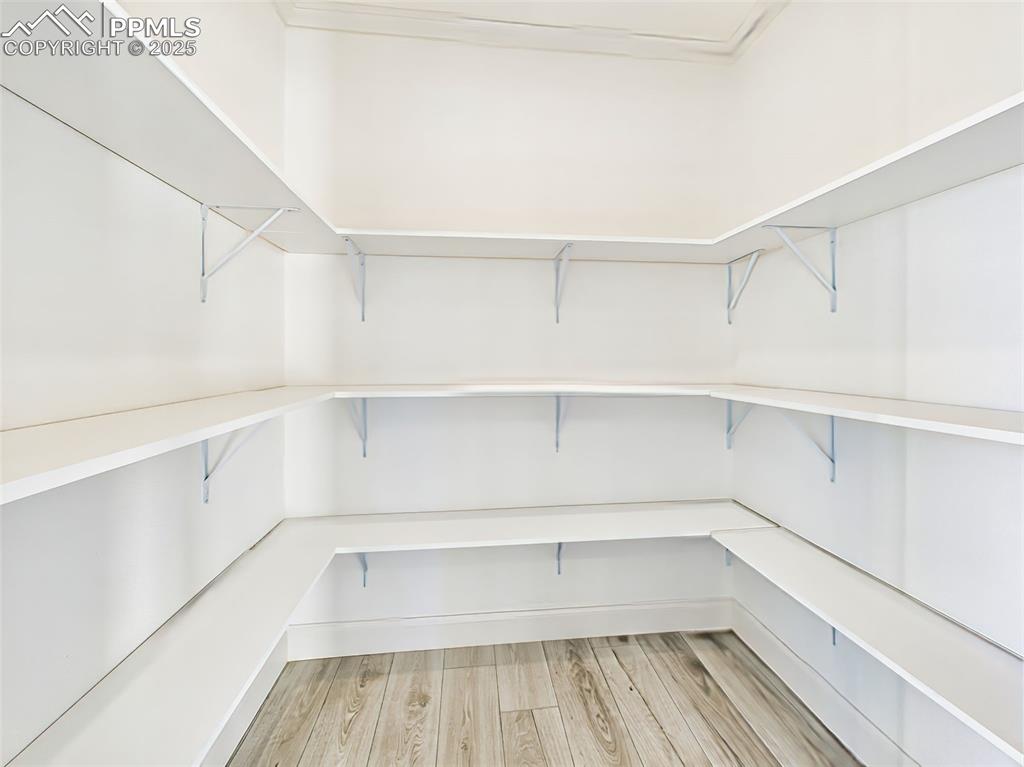 Walk-in pantry with wraparound shelving for ample kitchen storage and organization.