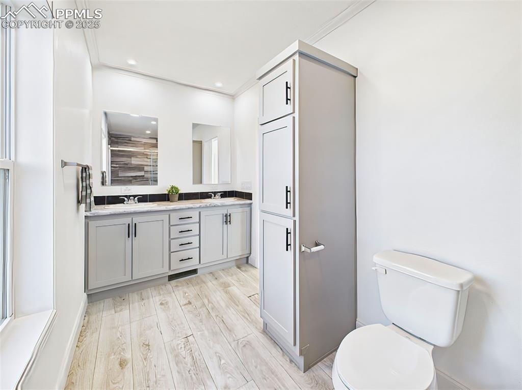Bright primary bath with modern finishes, large mirror, and high ceilings.