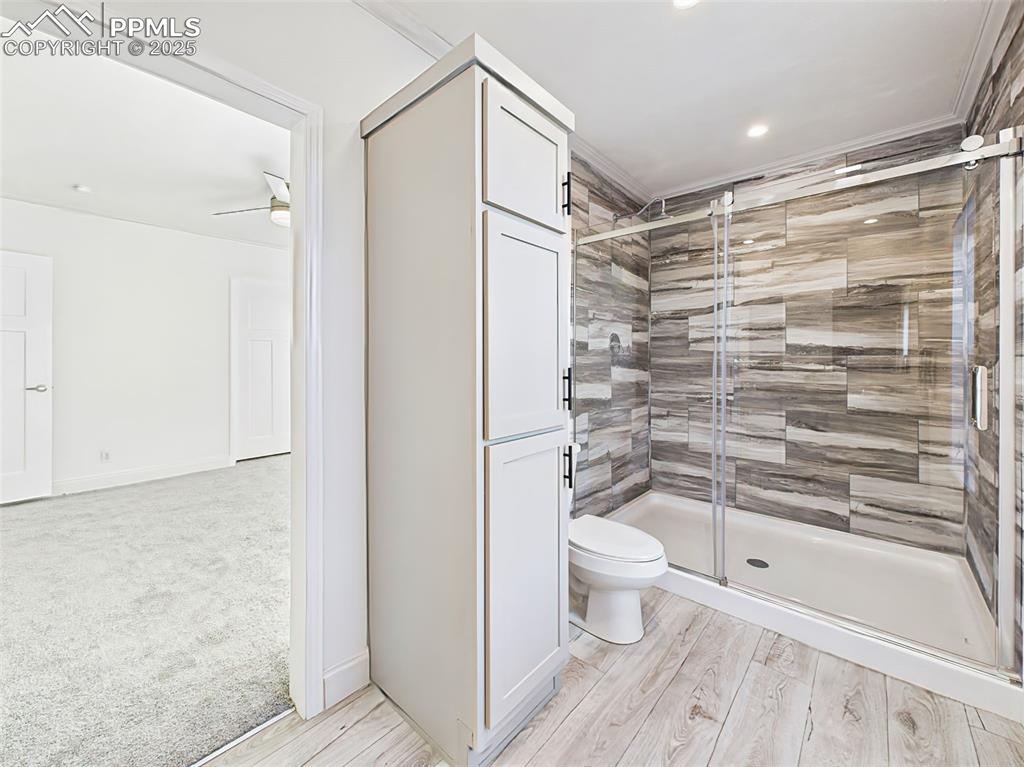 Spacious walk-in shower with full tile surround and built-in linen cabinetry.