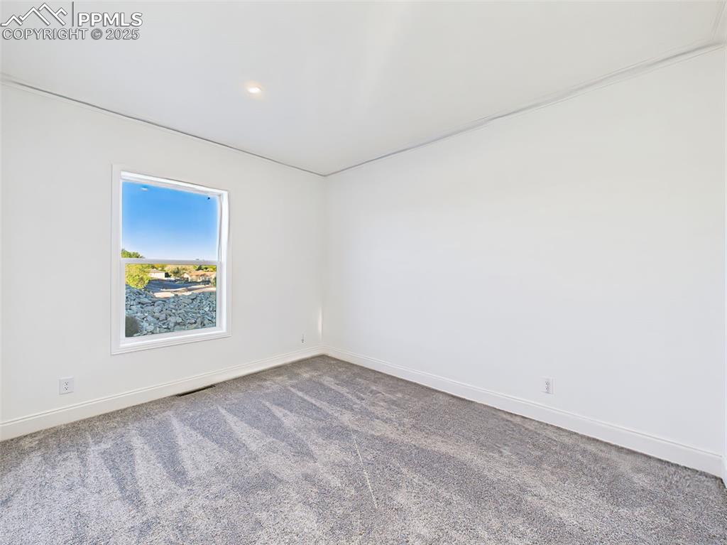 Unstaged version bedroom 3 highlighting new carpet, recessed lighting, and neutral palette.