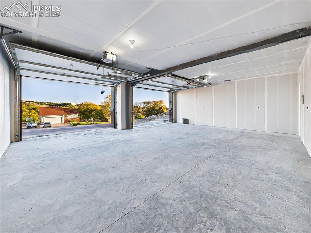 Massive finished 21' x28' garage with high ceilings and room for vehicles, storage, or workshop setup.