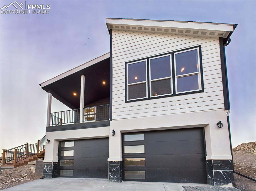 Contemporary elevation with striking black-and-white contrast, garage, and architectural windows.