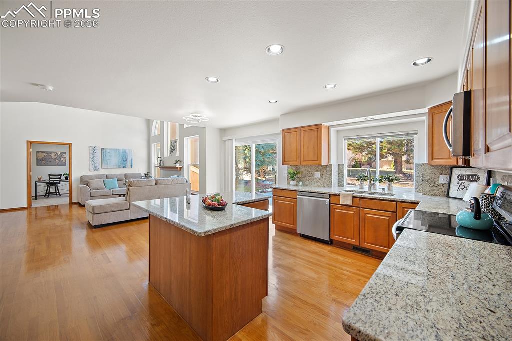 Open concept. Kitchen features granite, new SS appliances, island and pantry. 