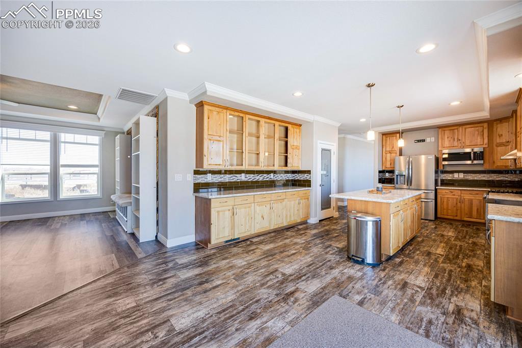 Kitchen with decorative backsplash, hanging light fixtures, recessed lighting, crown molding, and dark wood-style floors