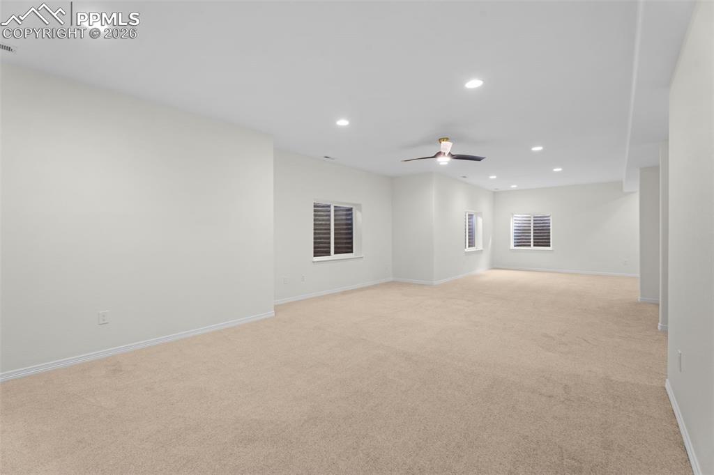 Spare room featuring recessed lighting, light carpet, and a ceiling fan