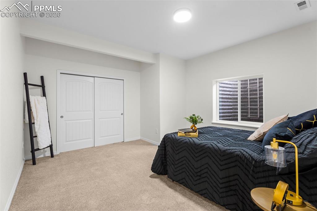 Bedroom featuring light carpet and a closet