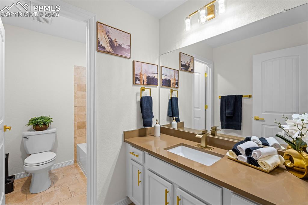 Full bathroom featuring vanity, shower / washtub combination, and light stone finish floors