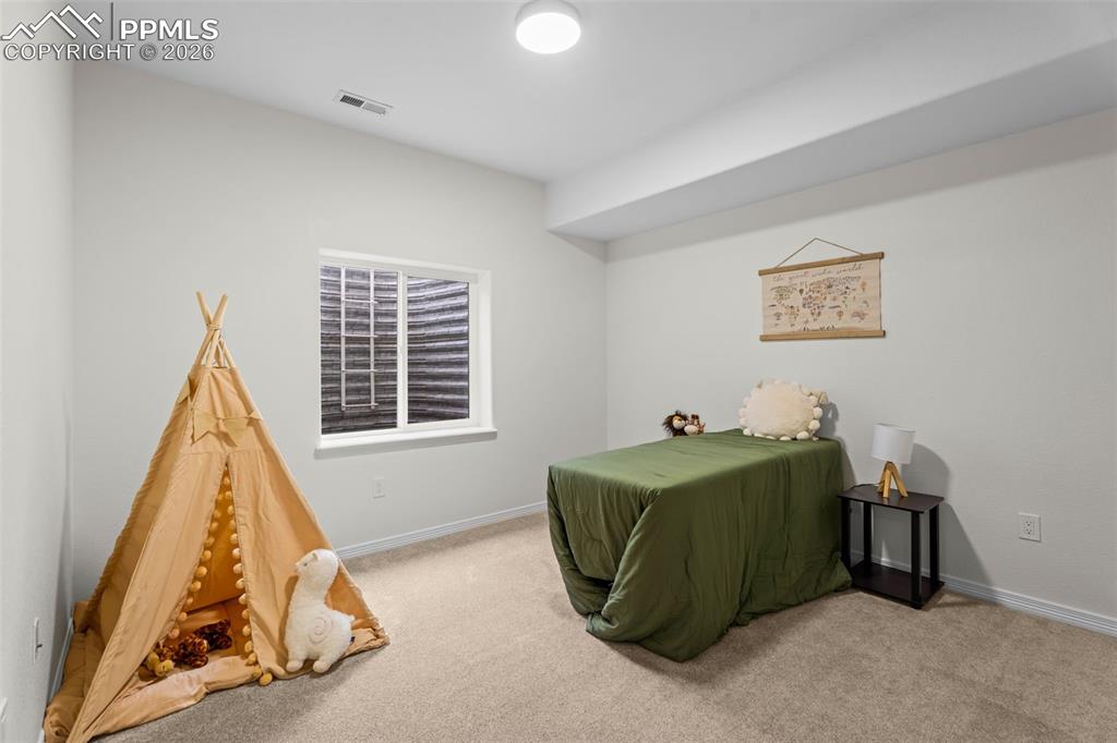 Bedroom featuring light carpet and baseboards