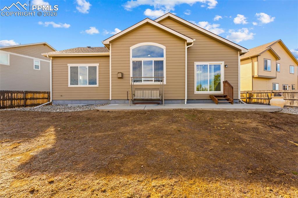 Rear view of property featuring a fenced backyard and a patio