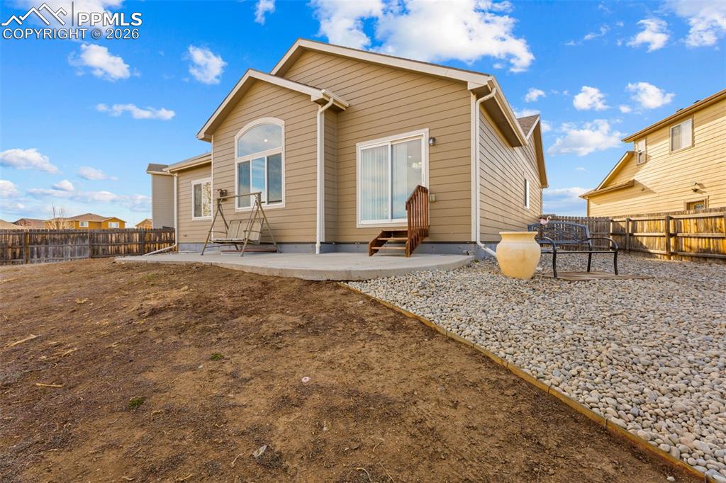 Rear view of property featuring a patio area and a fenced backyard