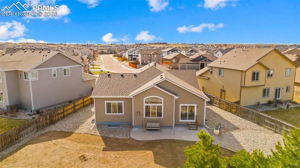Rear view of property featuring a patio, a residential view, a shingled roof, and a fenced backyard