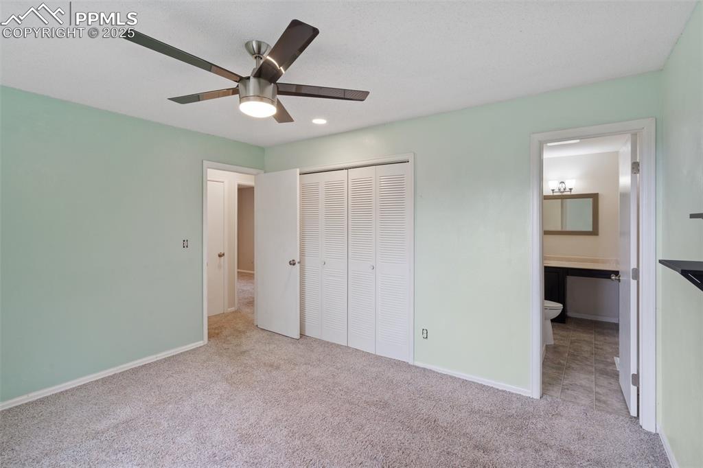 Primary bedroom featuring light carpet, a closet, a ceiling fan, a connected bathroom, and recessed lighting