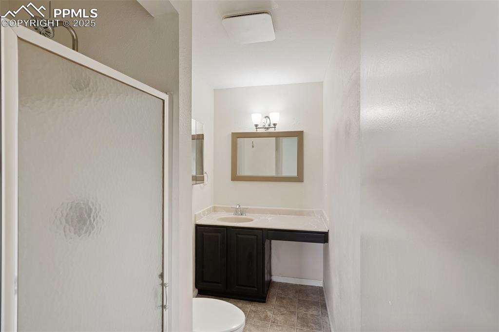 Primary Bathroom featuring vanity, a shower stall, and light tile patterned floors