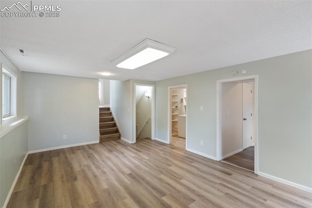 Lower level Family Room with stairway and light wood finished floors