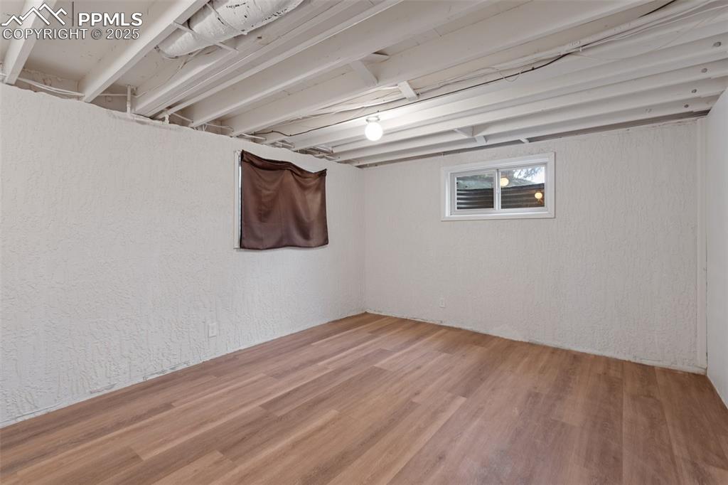 Basement Bedroom  featuring a closet, a textured wall, and wood-finished floors