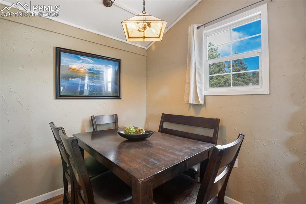 Dining space with a textured wall and ornamental molding