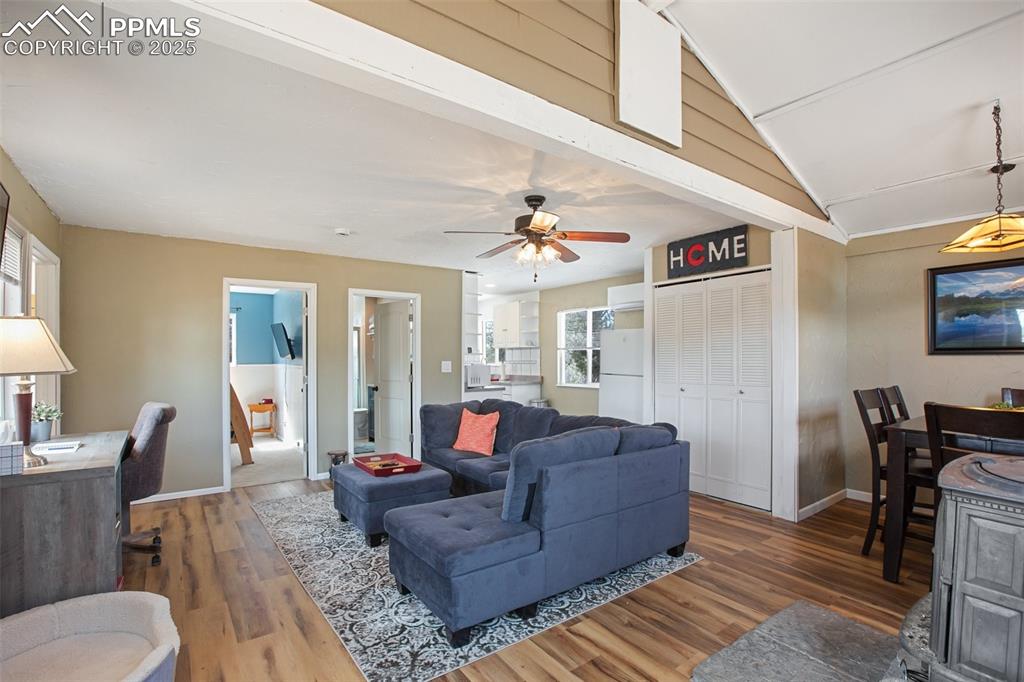 Living area featuring lofted ceiling, wood finished floors, and ceiling fan