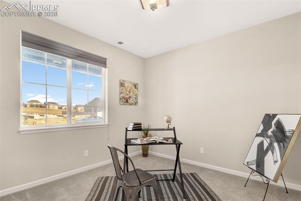 Front bedroom or office with a large window 