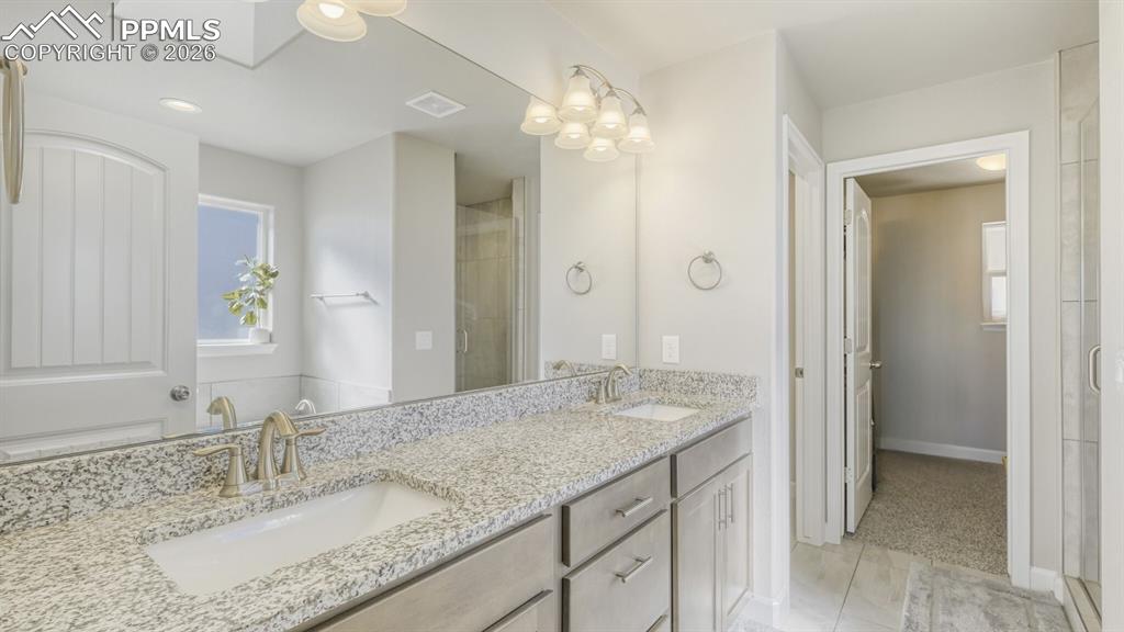 double vanity in primary bathroom with walk-in closet