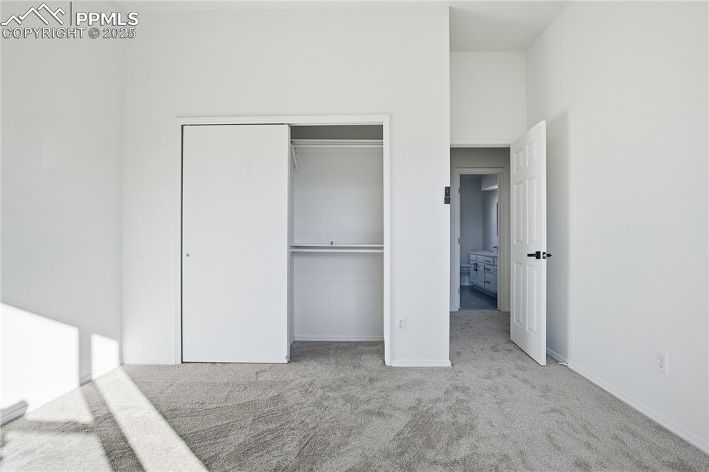 Unfurnished bedroom featuring light colored carpet and a closet