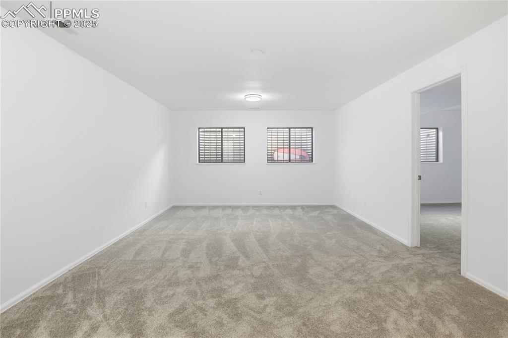 Unfurnished room with light colored carpet and baseboards