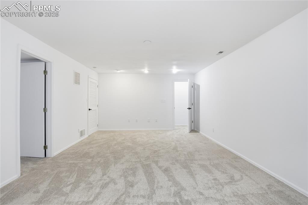 Unfurnished room with light carpet and baseboards