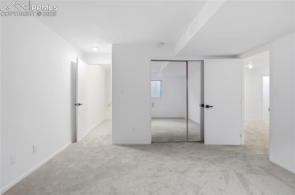 Unfurnished bedroom featuring light carpet and a closet