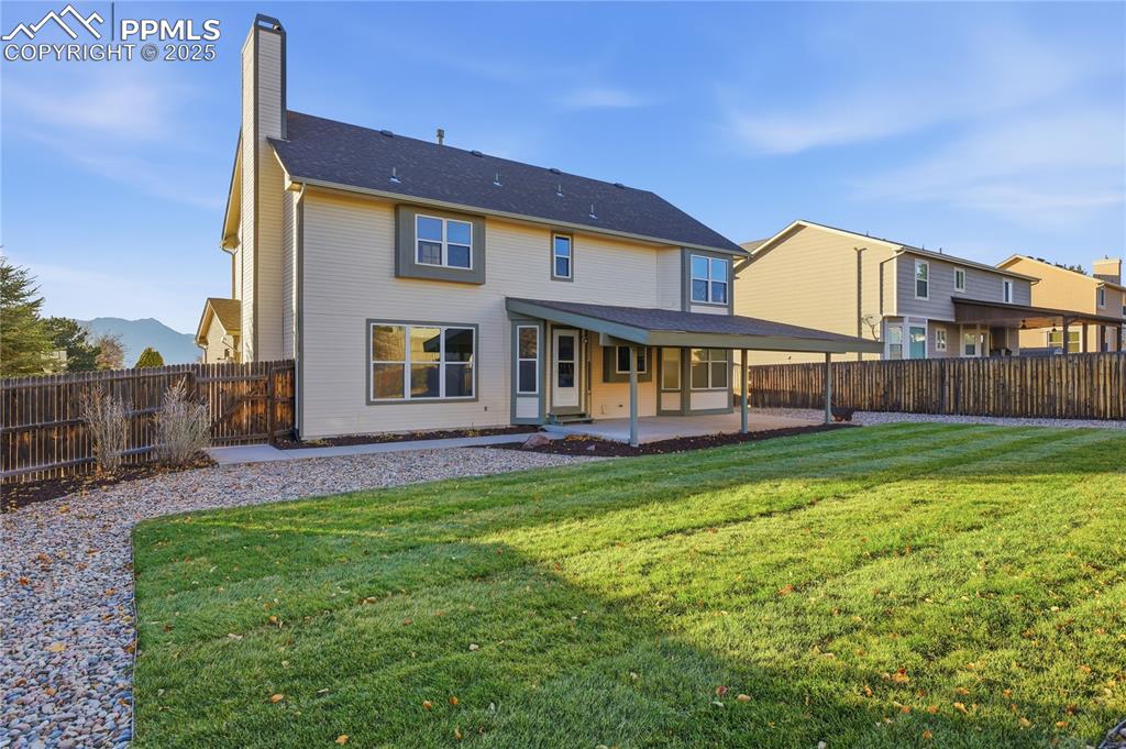 Back of house with a patio area, a chimney, and a fenced backyard