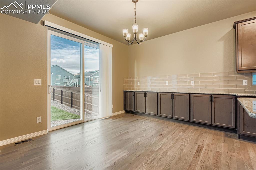 Unfurnished dining area featuring light wood-style floors and a chandelier