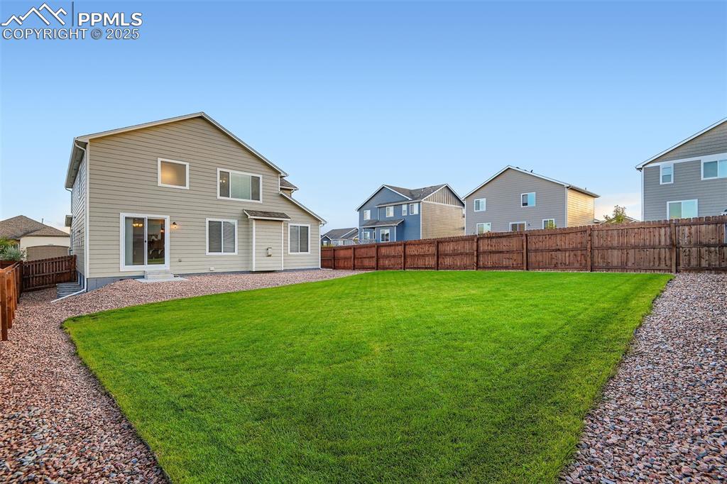 Rear view of house with a fenced backyard