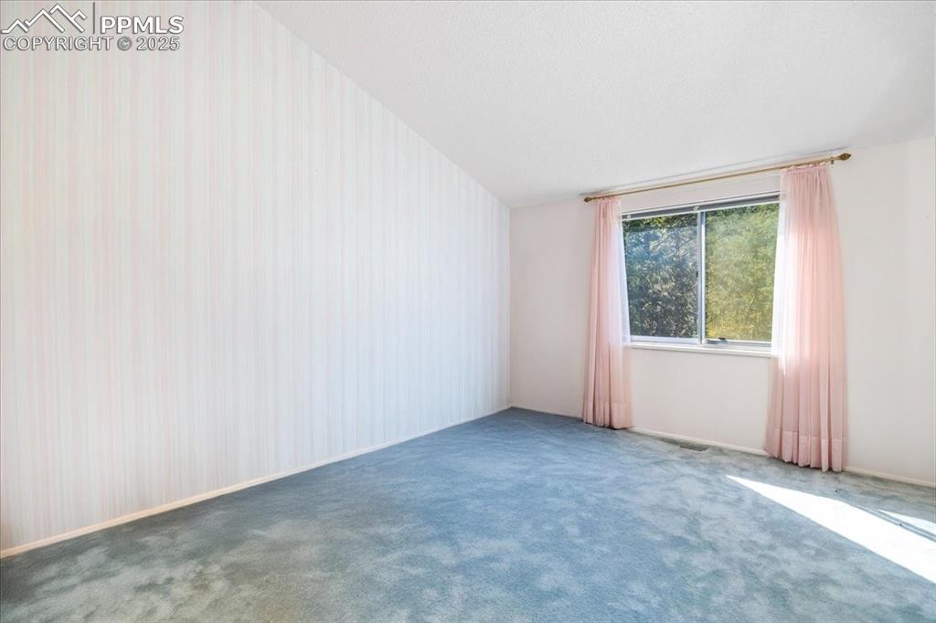 Carpeted spare room with baseboards