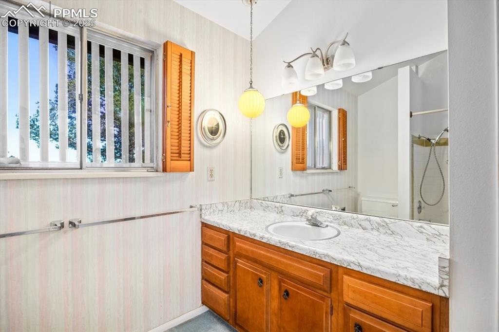 Full bath featuring vanity and wallpapered walls