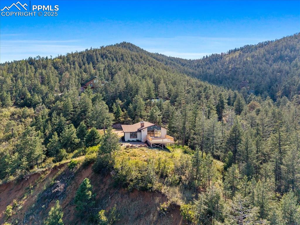 Aerial overview of property's location featuring a heavily wooded area and a mountainous background