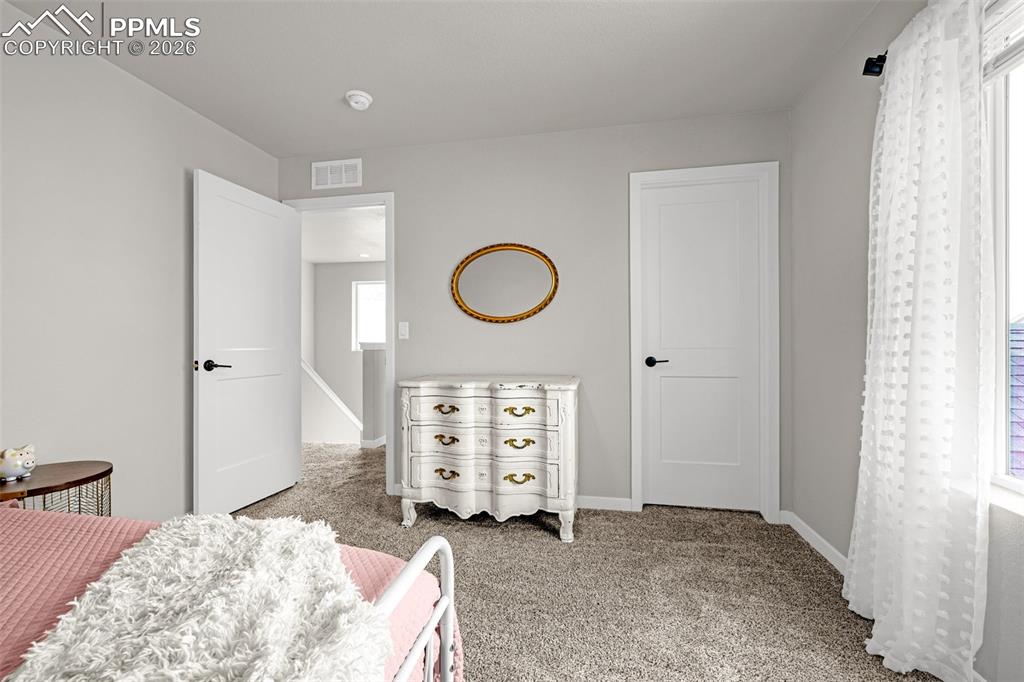 Second spacious bedroom on the upper level with fresh clean carpet, great natural light, and sizable closet 