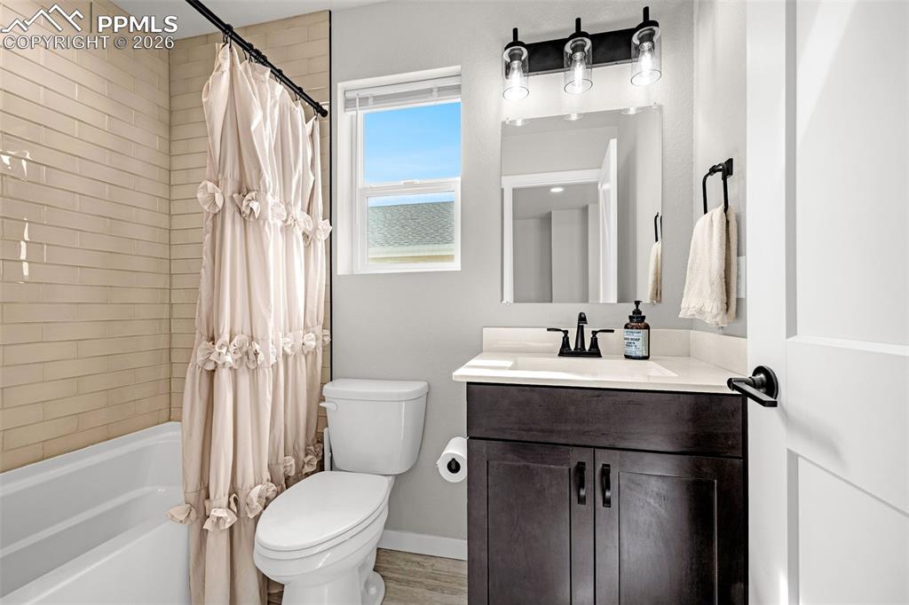 Second full bathroom on the upper level featuring a granite vanity and shower / bathtub combination with upgraded fixtures and finishes
