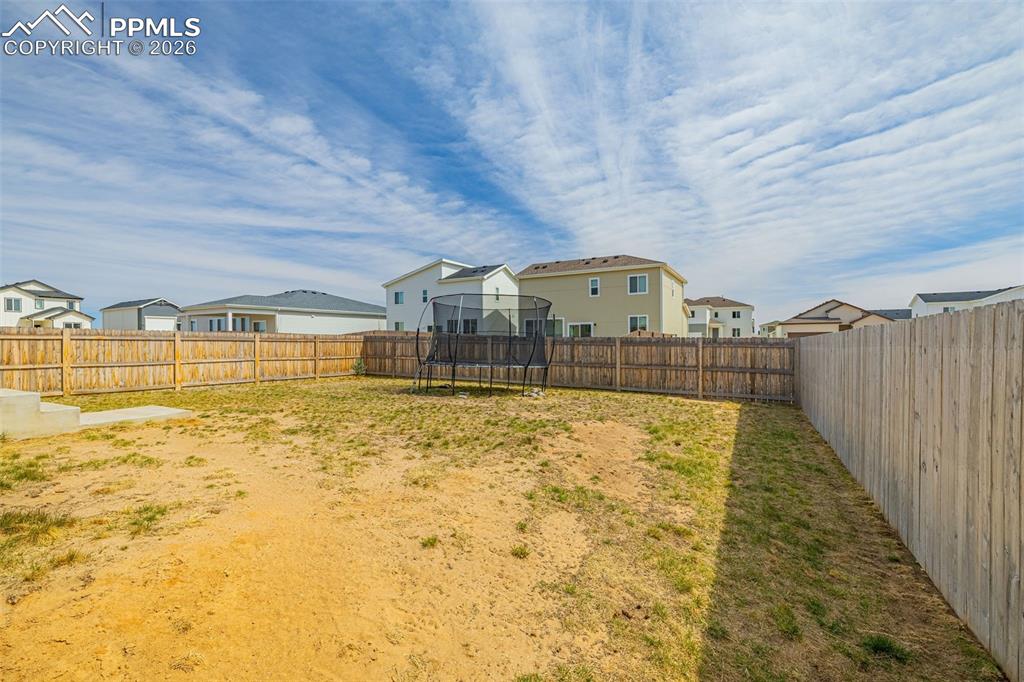 Rear view of house featuring a large fenced in backyard for privacy 