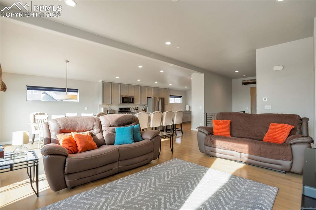 Living room with real white oak flooring, vaulted beamed ceiling and recessed lighting