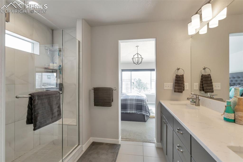 Primary Bathroom #1 featuring connected bathroom, double vanity, a stall shower, and plenty of natural light