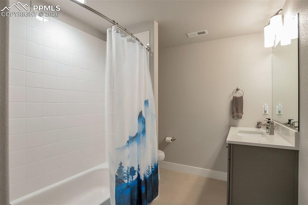 Primary Full bathroom #3 in Basement for Primary Bedroom #2 featuring vanity, shower / bath combo, and light tile patterned flooring